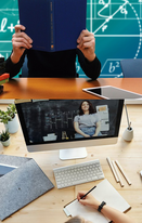 First-person view of a person at a desk, with a monitor in front of them.